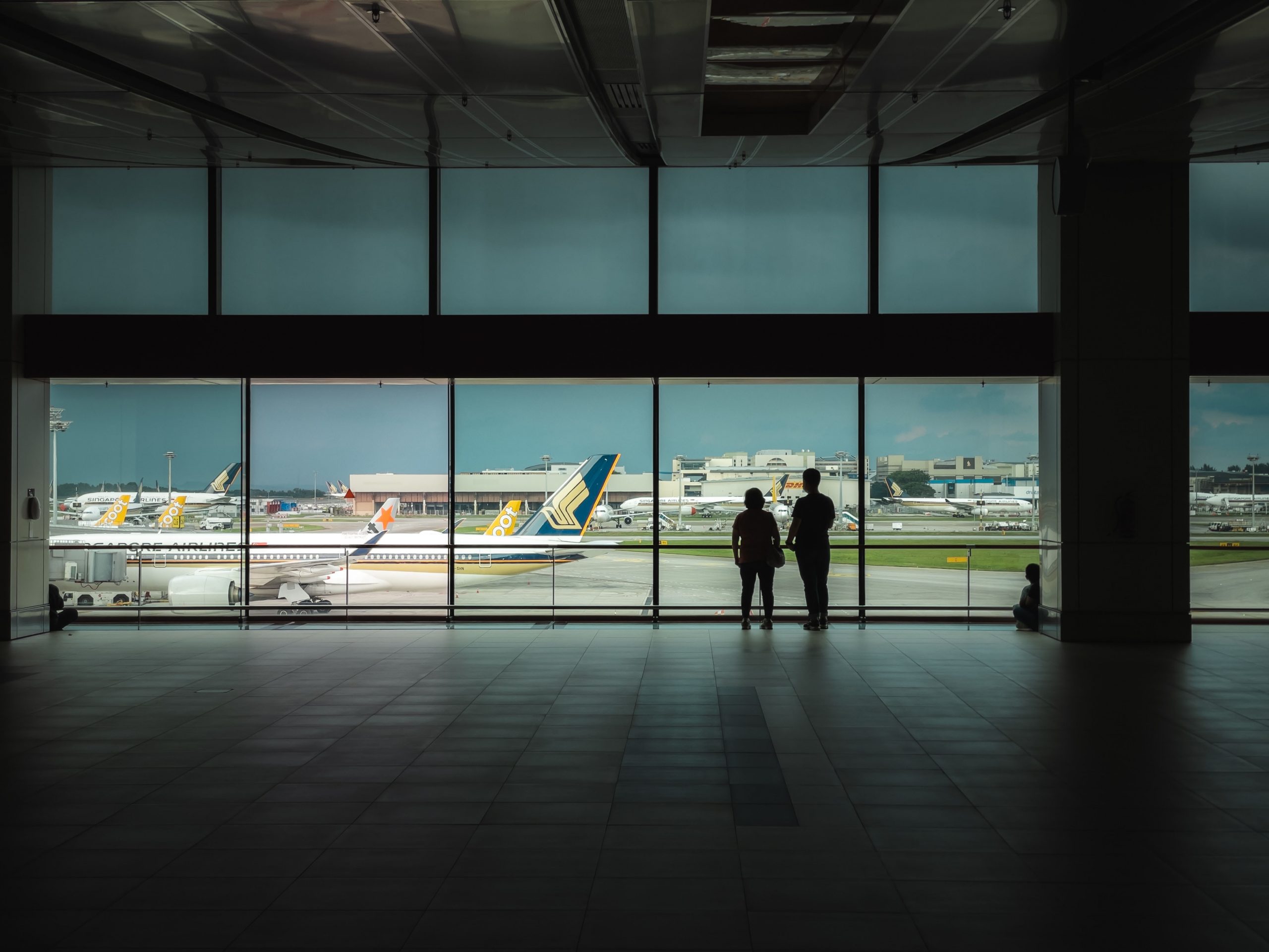Dos personas contemplando un avión en un aeropuerto.